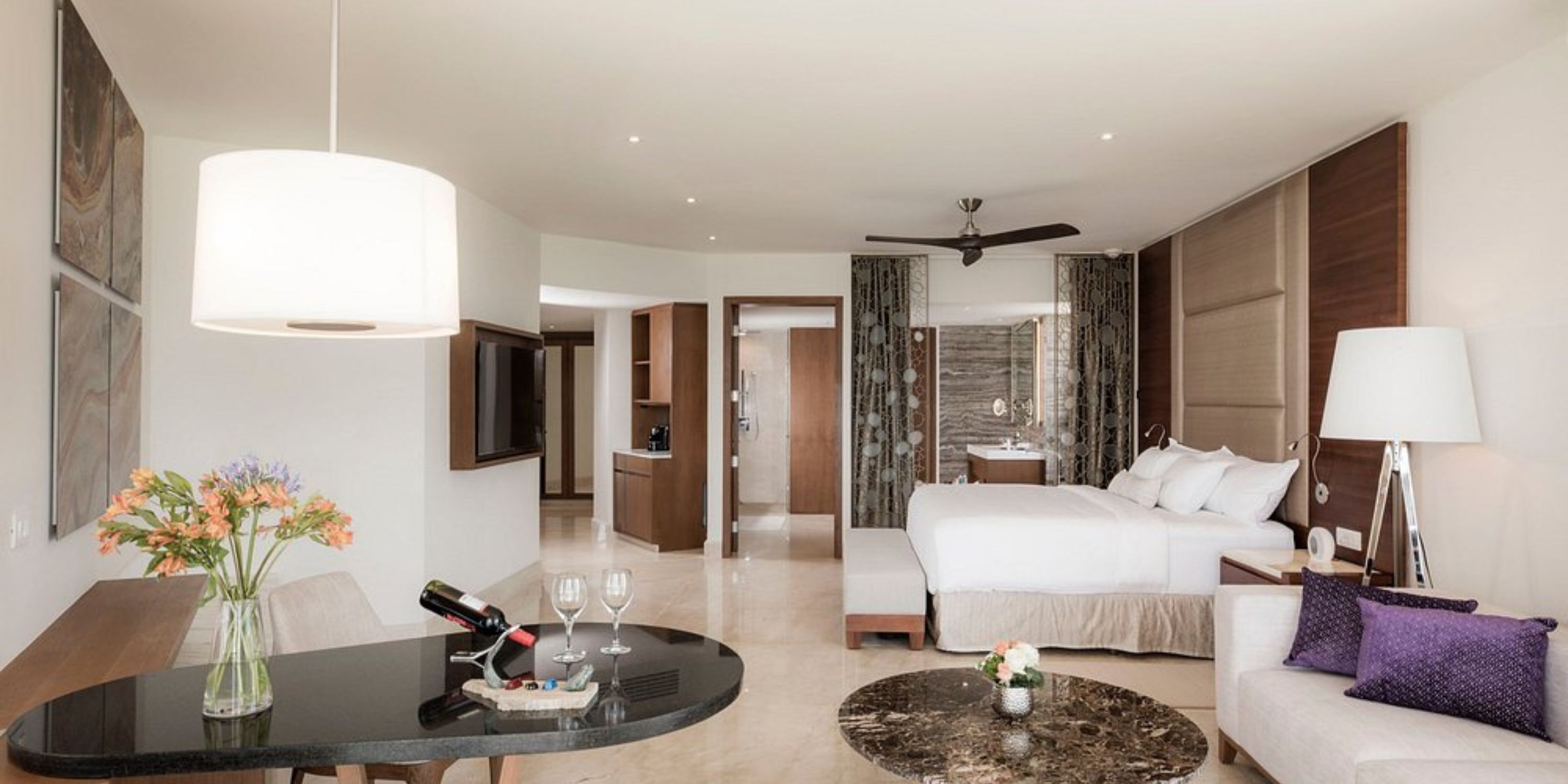 Elegant suite at Le Blanc Spa Resort Los Cabos, ideal for destination weddings, with bed and sitting area.