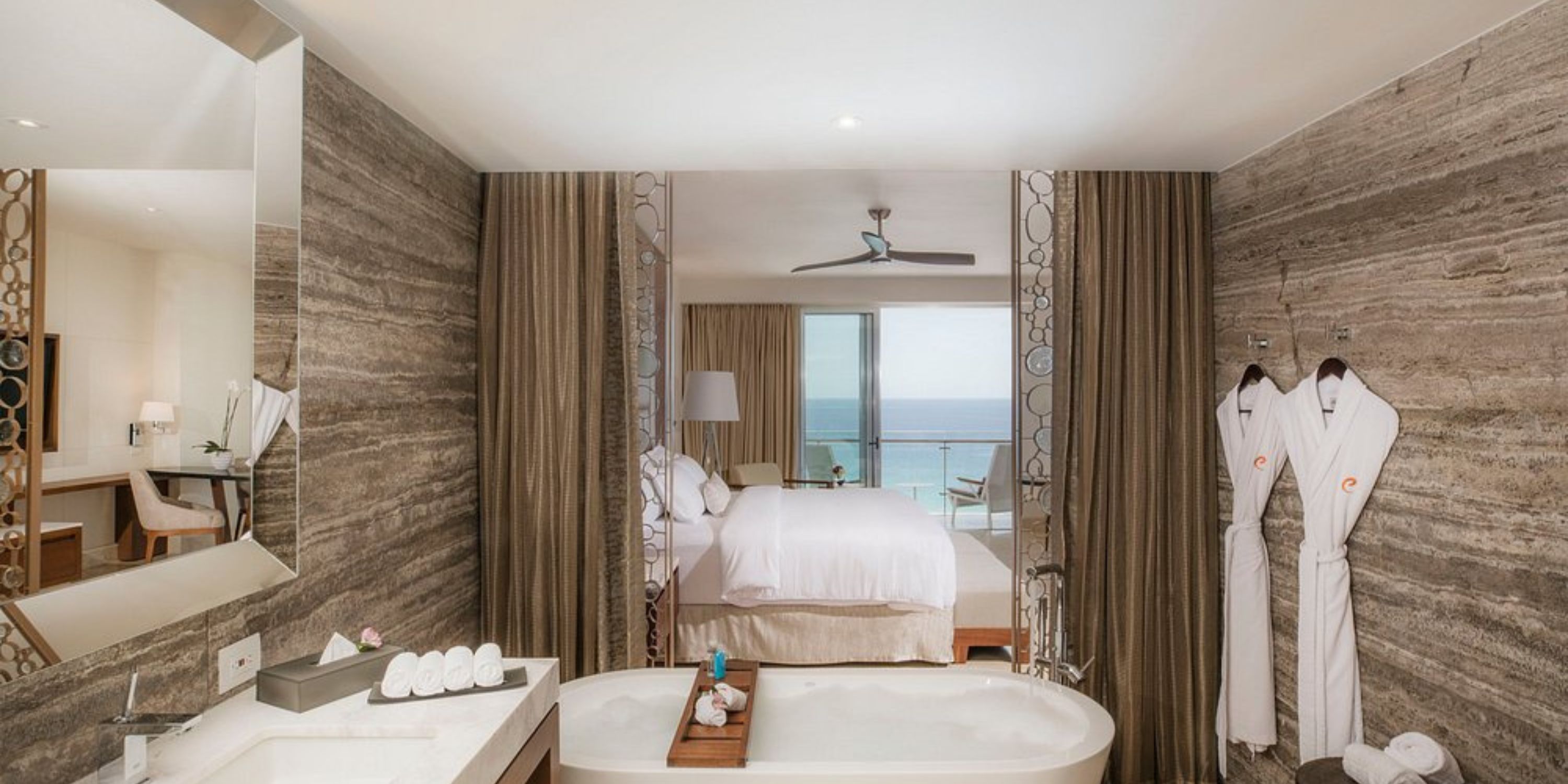 Modern hotel bathroom at Le Blanc Spa Resort Los Cabos, perfect for a destination wedding, with tub, robes, and ocean view.