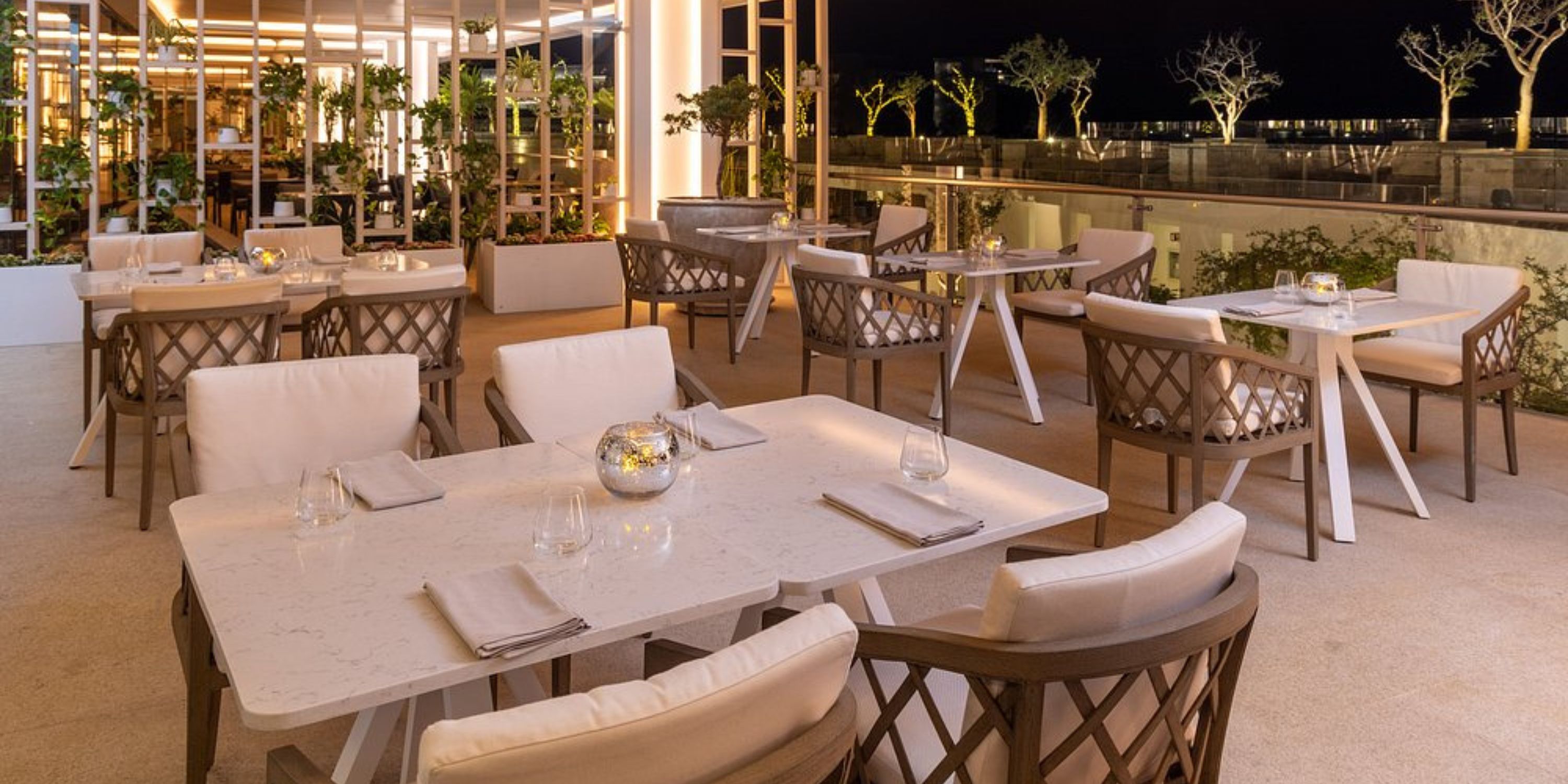 Le Blanc Spa Resort Los Cabos patio at night, set for a destination wedding with tables and soft lighting.