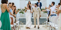 Bride and groom walk down the aisle to applause during a destination wedding at Le Blanc Spa Resort Los Cabos.