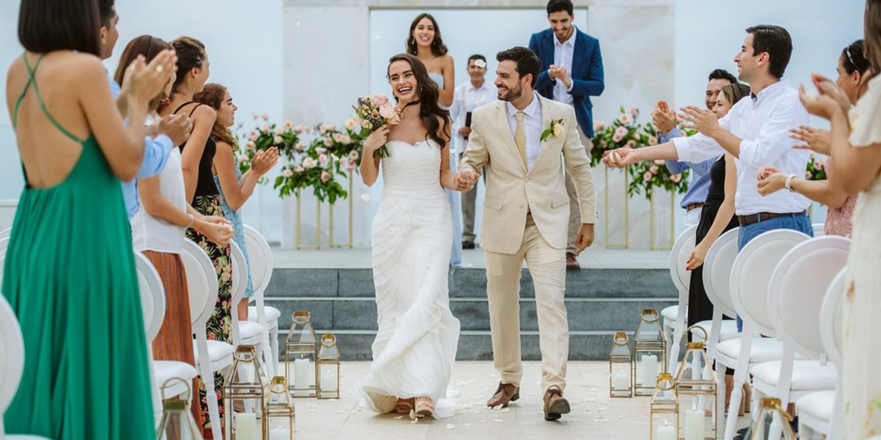 Bride and groom walk down the aisle to applause during a destination wedding at Le Blanc Spa Resort Los Cabos.
