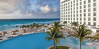 Le Blanc Spa Resort: A modern, adults-only beachfront hotel featuring a stunning pool, swaying palm trees, breathtaking ocean views—an ideal choice for a romantic destination wedding.
