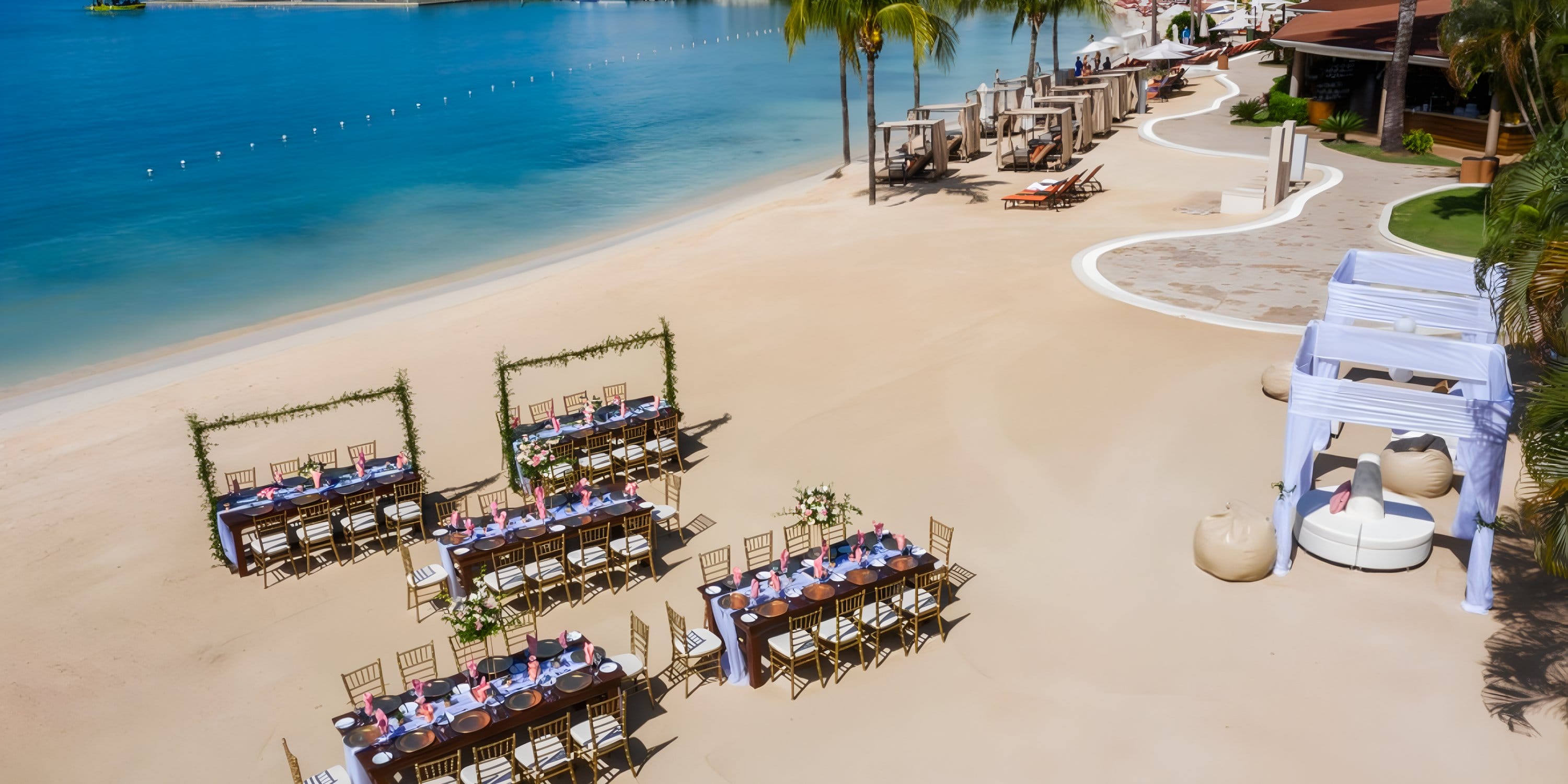 Destination wedding setup with tables and chairs on the beach amid palms and cabanas at Moon Palace.