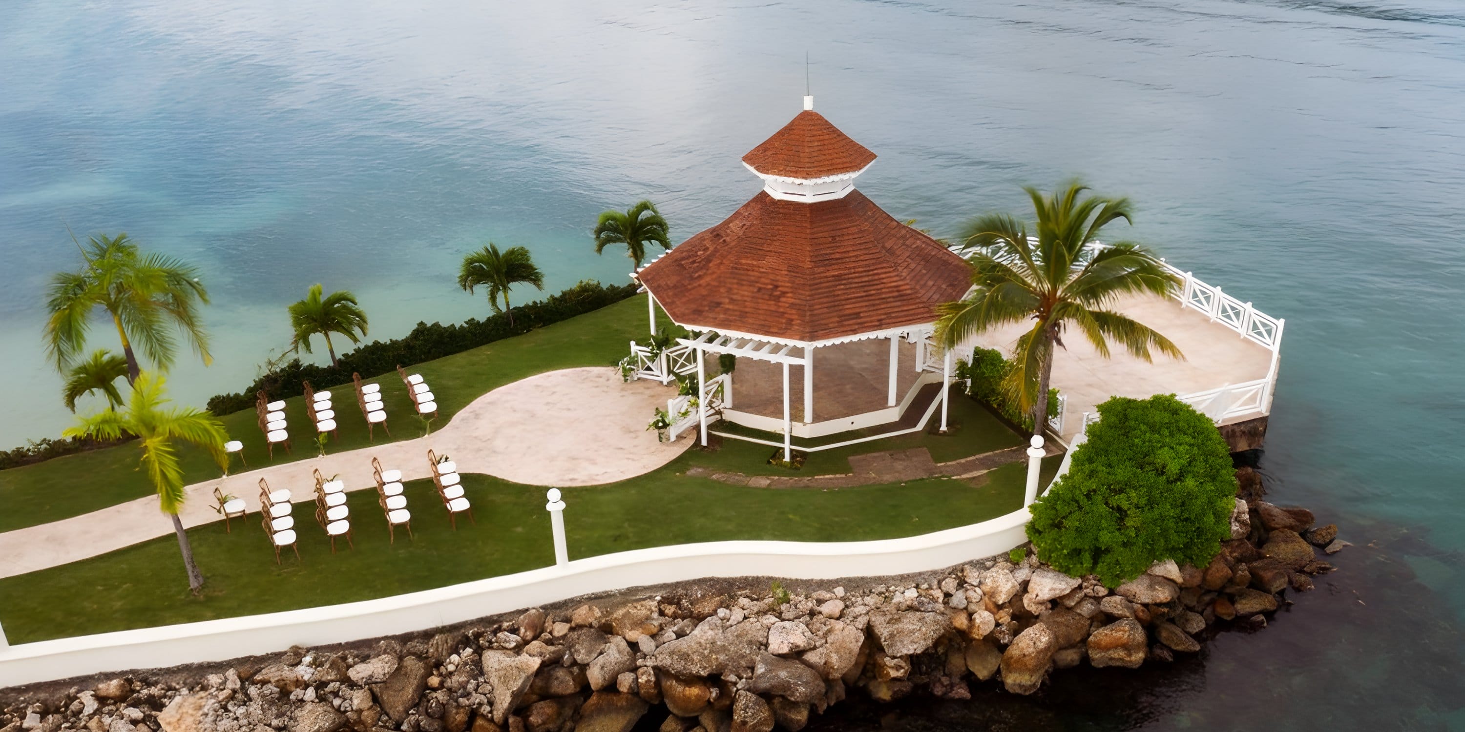 Moon Palace Jamaica: red-roof gazebo, palm trees, white chairs—ideal for a destination wedding.