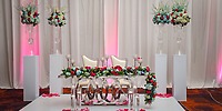Wedding sweetheart table at Moon Palace Jamaica with two chairs, flowers, and rose petals for a destination wedding.