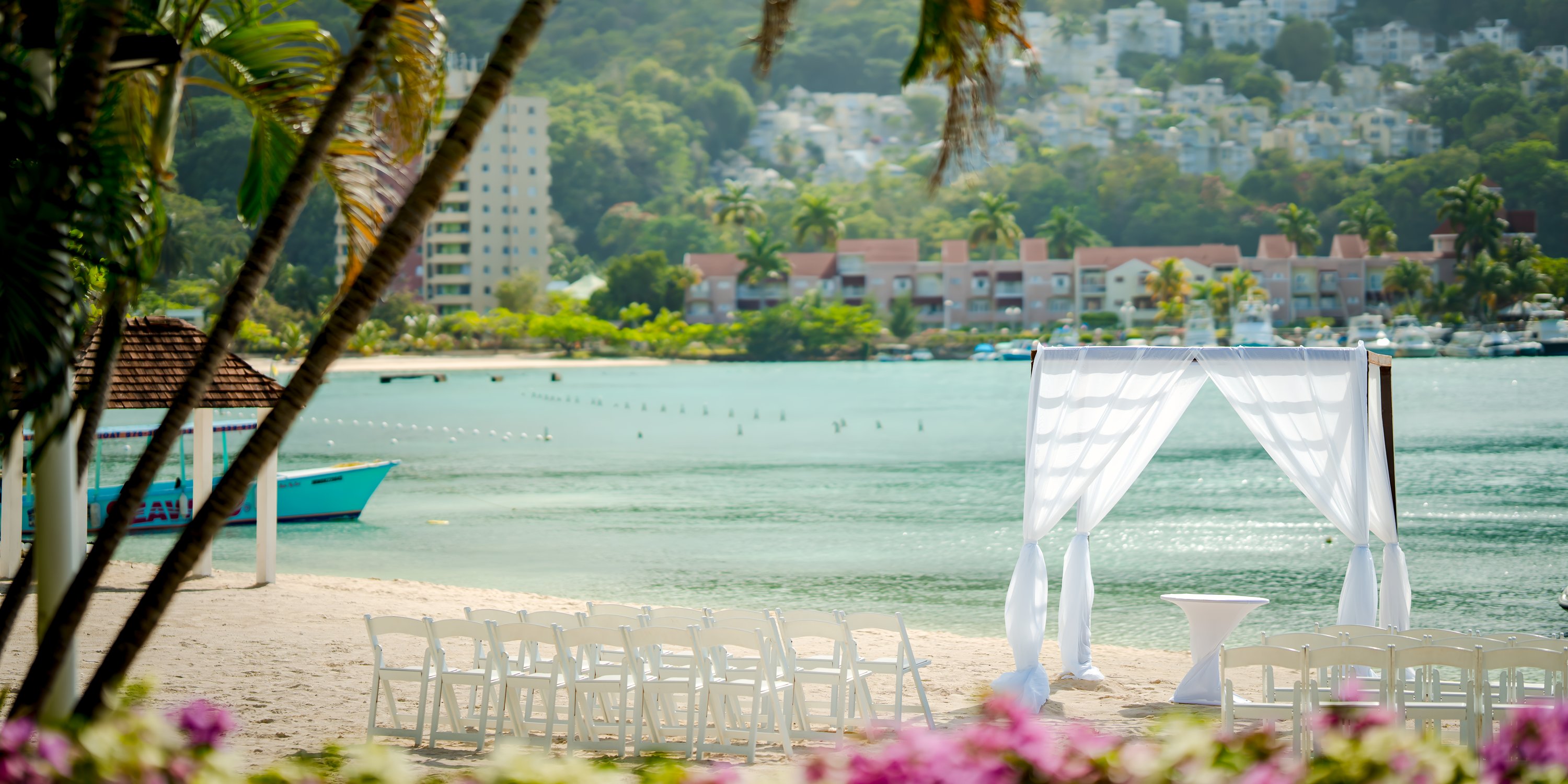 Wedding arch and chairs set up on the sandy beach by the water at Moon Palace Jamaica destination wedding.