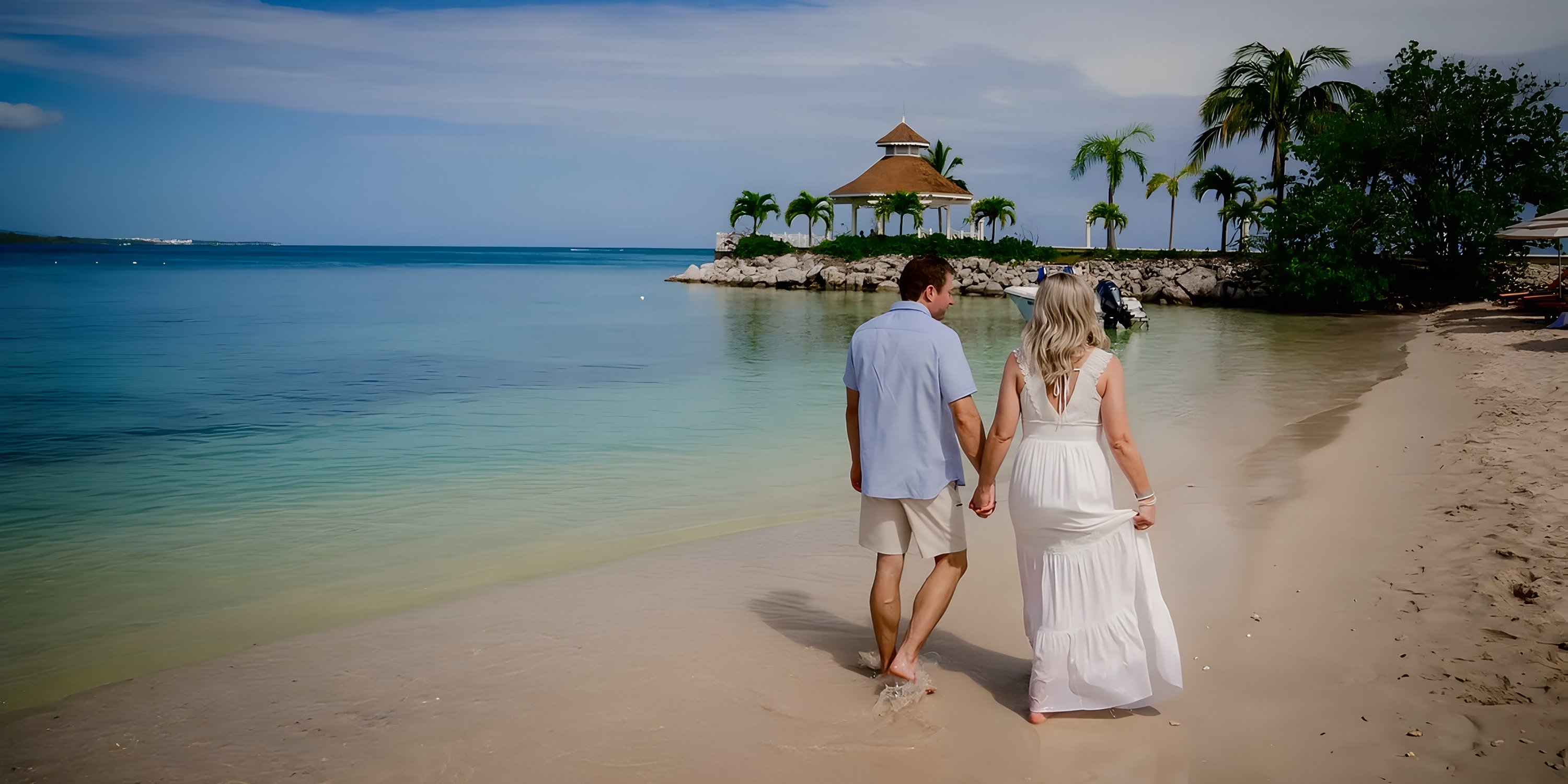 A couple strolls hand-in-hand on the beach at Moon Palace Jamaica, a dreamy destination wedding spot.