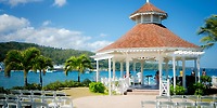 White gazebo at Moon Palace Jamaica set for a destination wedding, with chairs, palm trees, and mountain views.