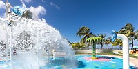 Moon Palace Jamaica splash pad, ideal for a destination wedding, has a large bucket and palm trees.