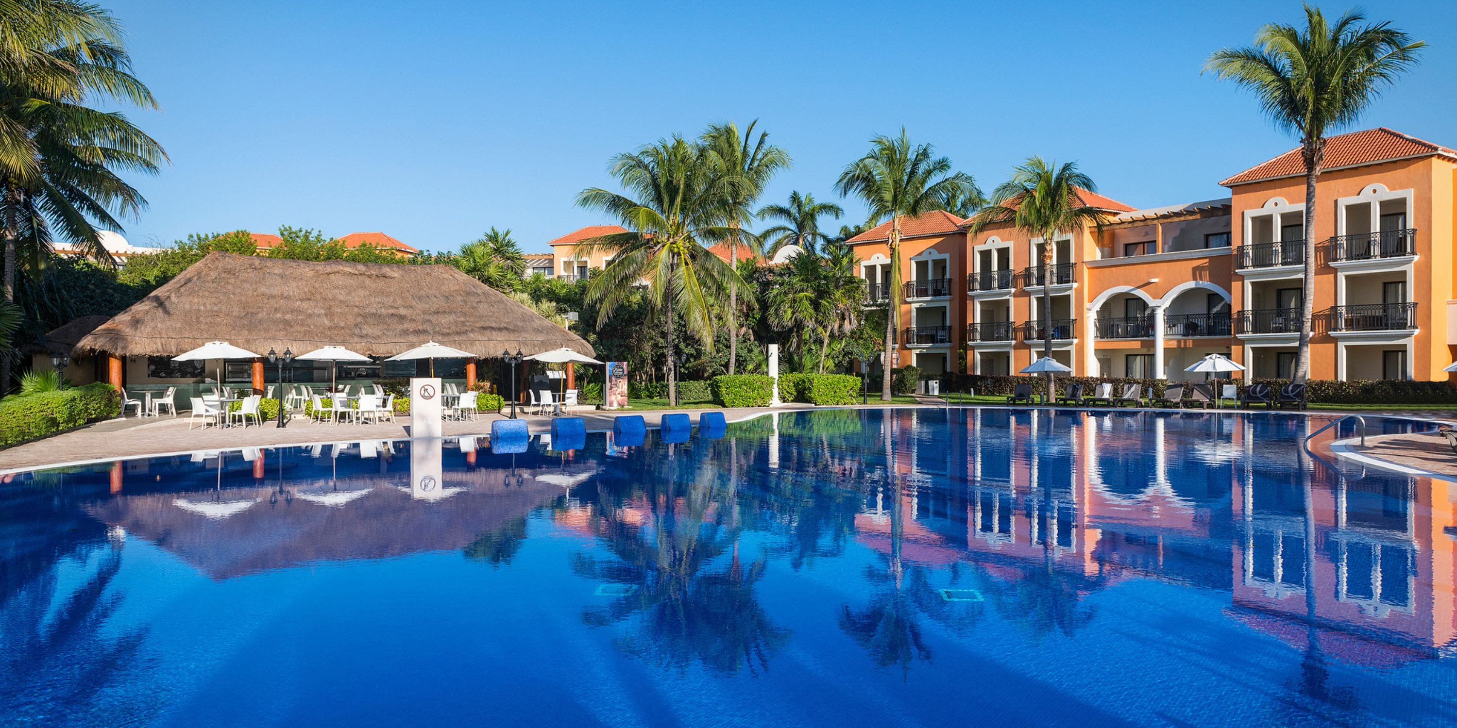 Ocean Coral and Turquesa: outdoor pool, lounge chairs, palm trees&mdash;ideal for a destination wedding.
