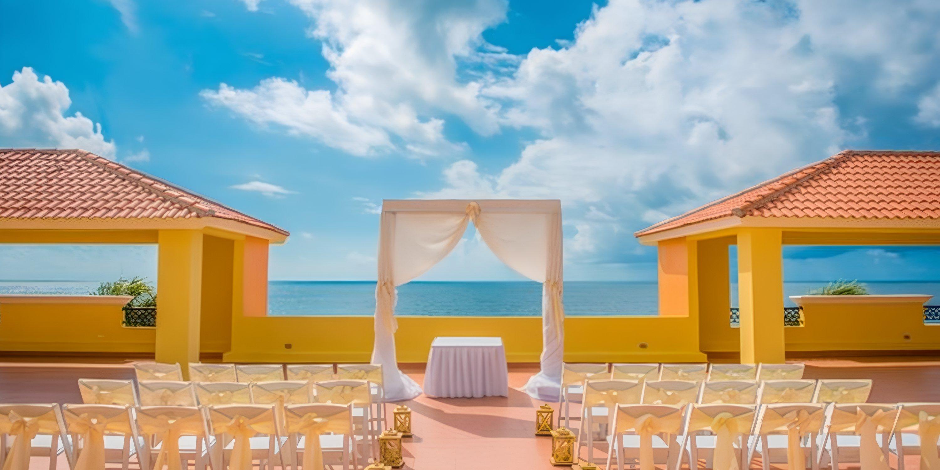Destination wedding setup at Ocean Coral and Turquesa with white chairs and altar overlooking the ocean.