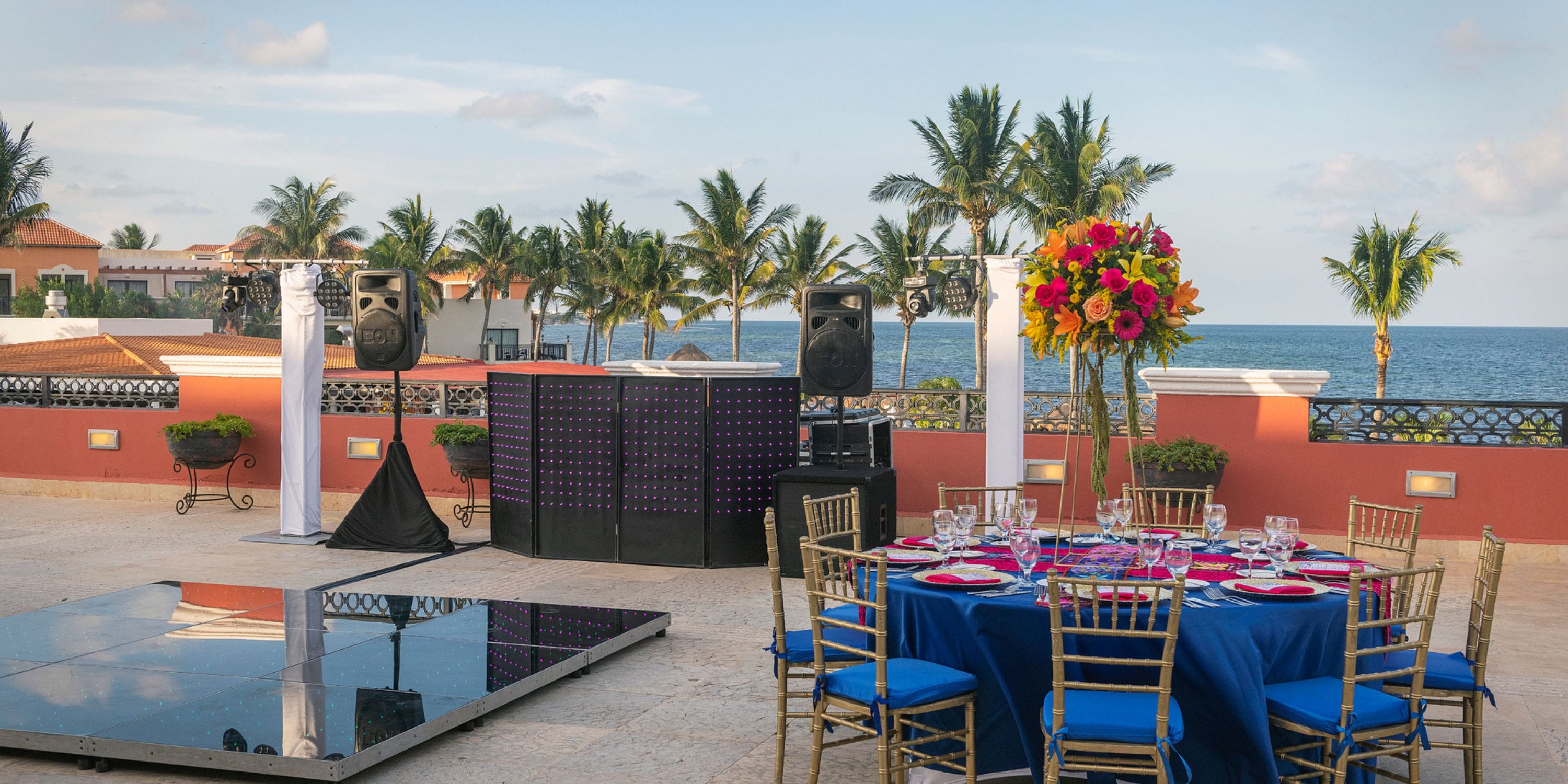Ocean Coral and Turquesa: destination wedding with DJ booth, dance floor, and seaside dining setup.