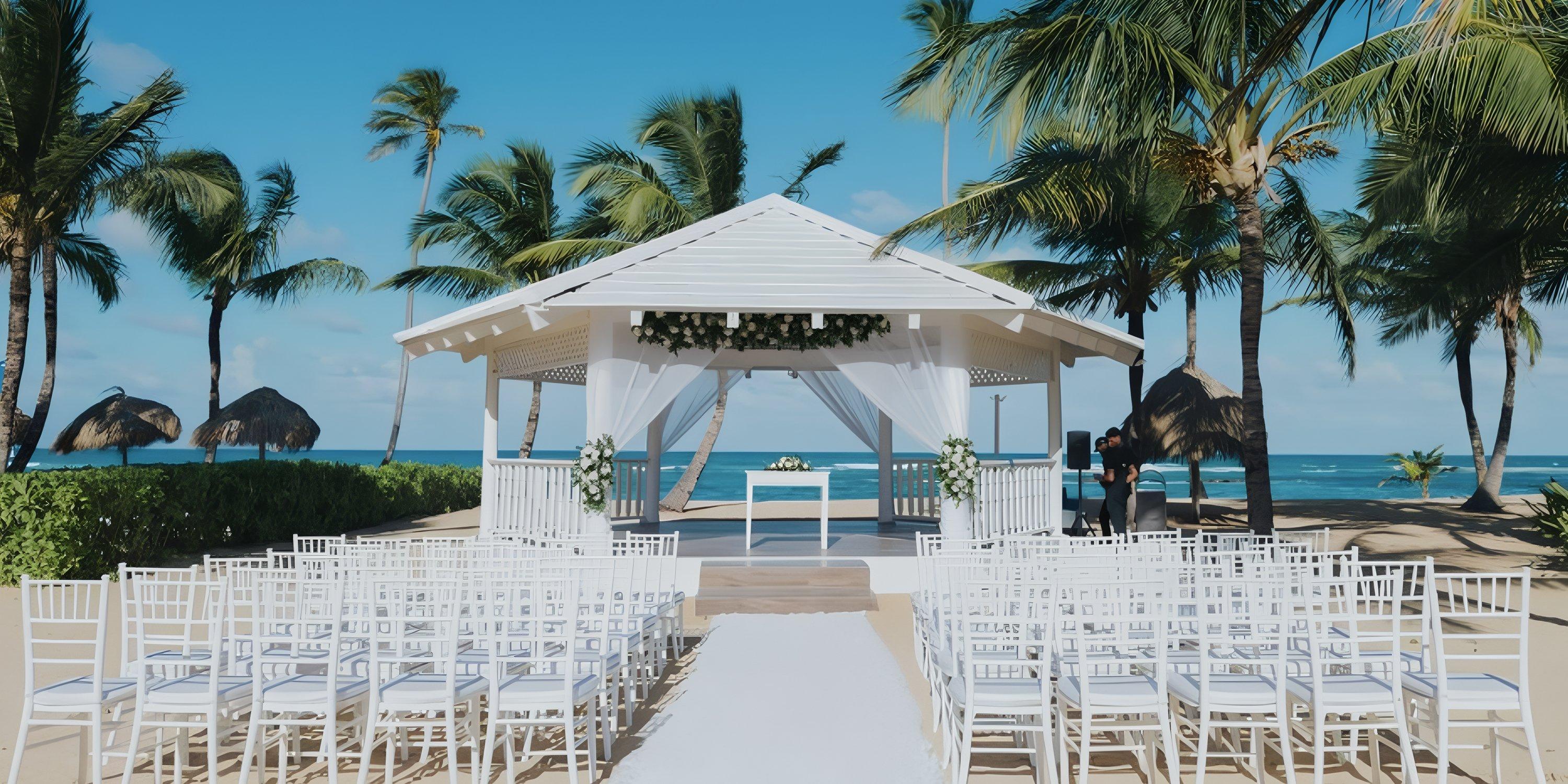 Destination wedding at Ocean El Faro: white chairs and a gazebo set beneath palm trees by the ocean.