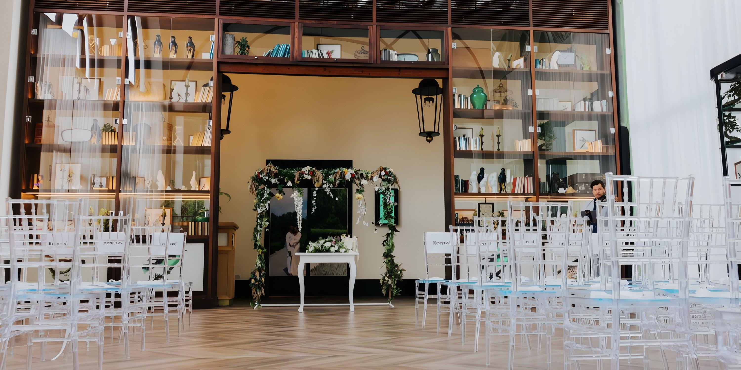 Ocean El Faro destination wedding setup with clear chairs, floral arch, and stylish decorative shelves.