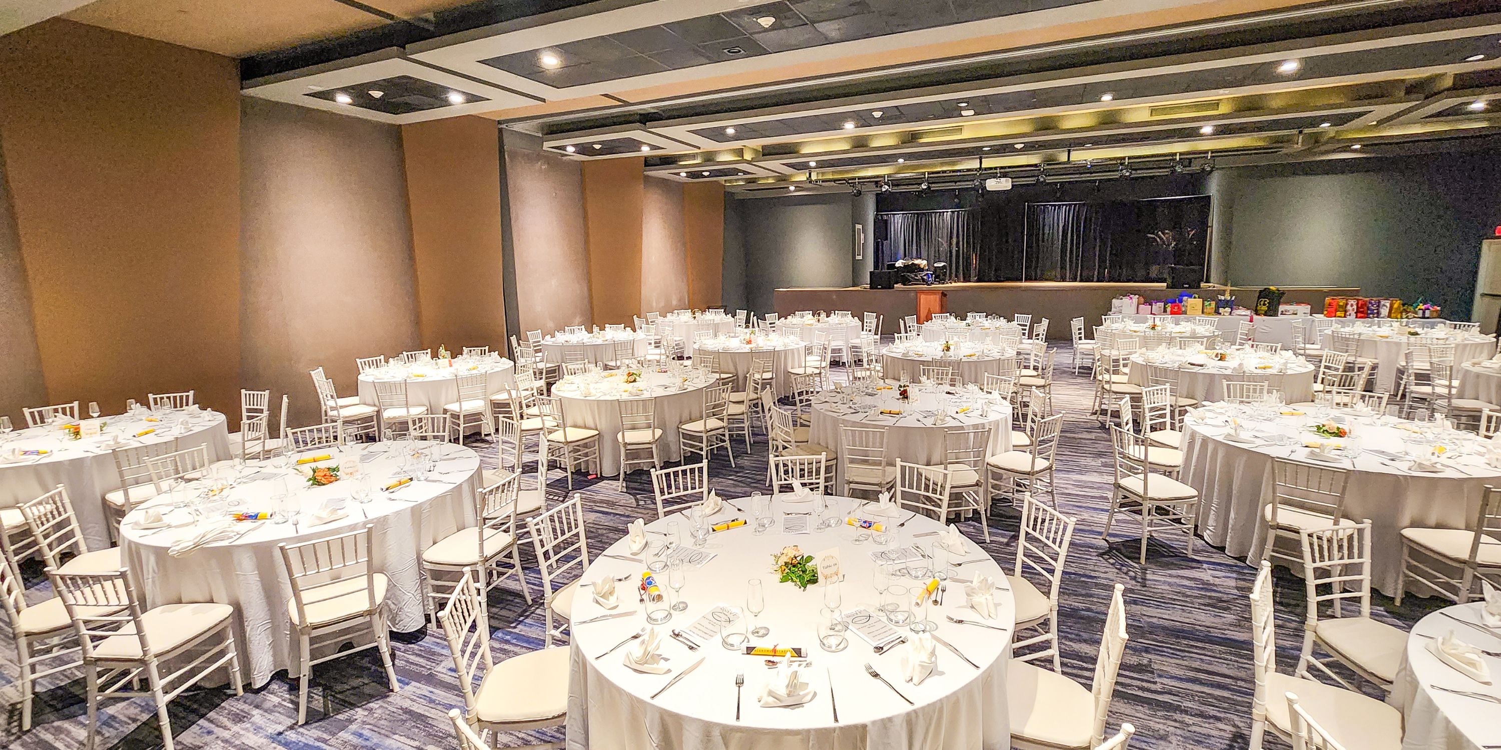 Royalton Antigua banquet hall arranged for a destination wedding, with round tables and white chairs.