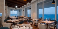 Sun Palace Cancun provides a contemporary seaside restaurant where set tables are enhanced by stunning ocean views, making it an ideal location for a destination wedding.
