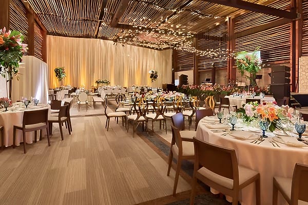 Hotel Xcaret: Elegant banquet hall set for a destination wedding, with florals and ambient lighting.
