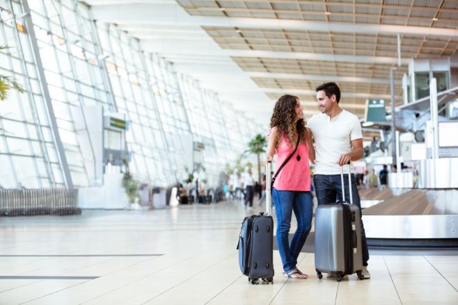 Couple retrieved their rolling bags at the baggage claim How Destfy can help airfare