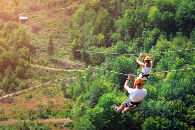 couple ziplining through jungle destination wedding excursions all-inclusive tours