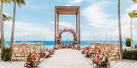 Destination wedding at Secrets Moxche Playa del Carmen with wooden altar, floral arch, and ocean backdrop.