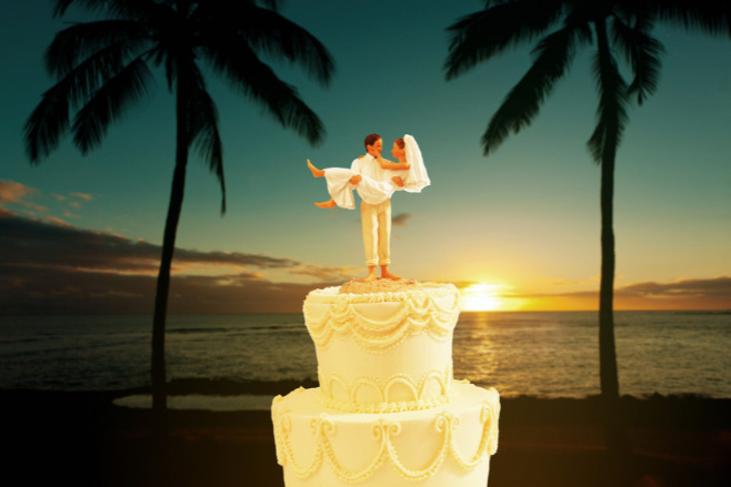 Miniature bride and groom atop a wedding cake with the gorgeous tropical backdrop