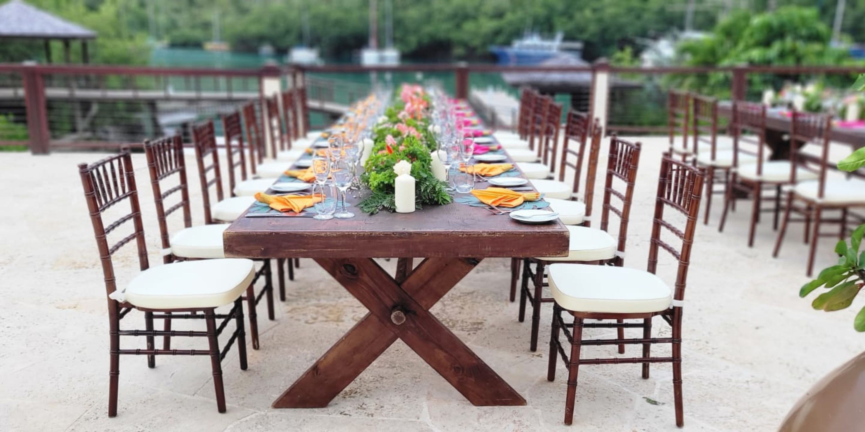 Zoetry Marigot Bay St. Lucia: Outdoor wooden table set for a destination wedding with plates and florals.
