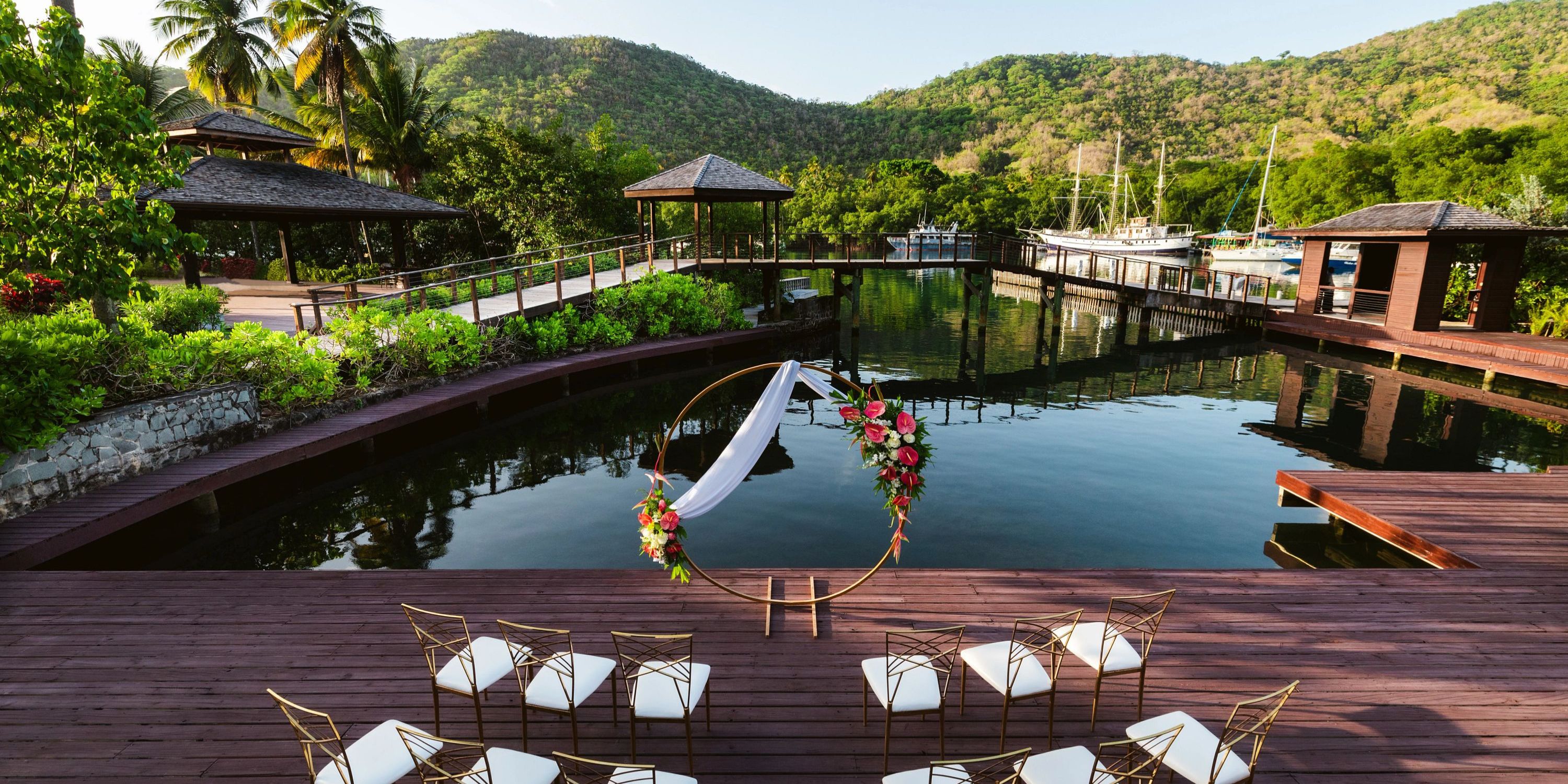 Destination wedding at Zoetry Marigot Bay St. Lucia: outdoor deck with chairs and a floral arch setup.