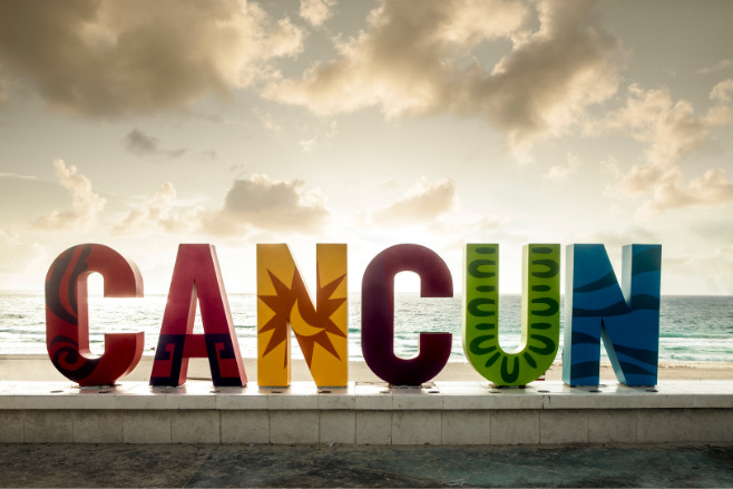 A Cancun sign with an overcast sky behind it