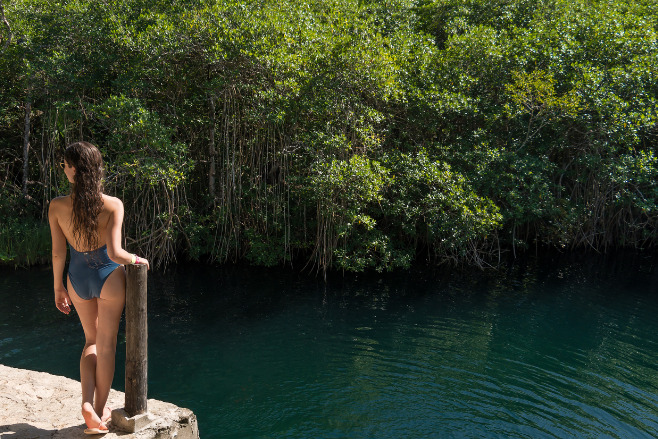 Woman standing in front of a cenote in cancun