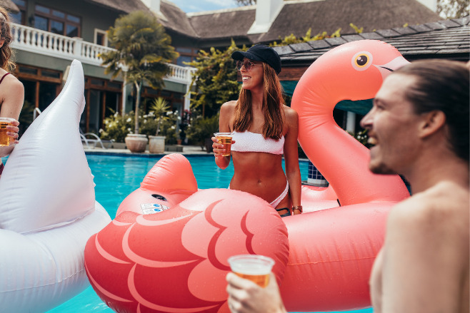 Friends in the pool during the shoulder dsetination wedding season