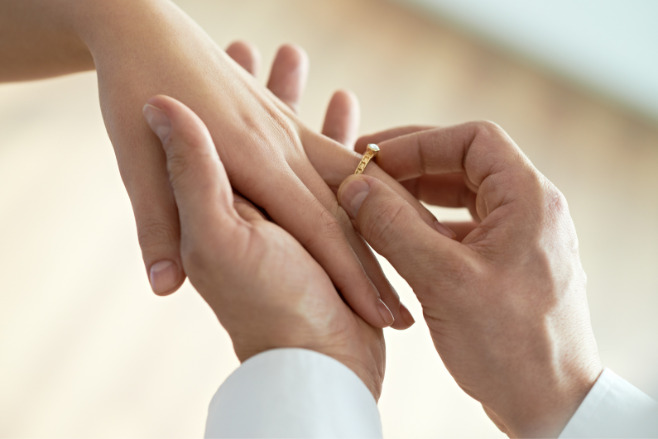 Engagement ring slipped onto the finger of a bride