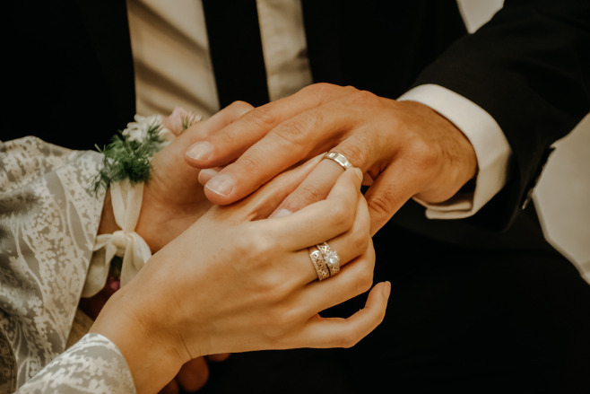 A destination wedding couple putting their wedding rings on each other's fingers