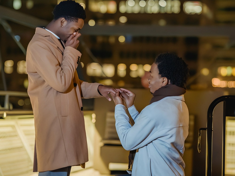 A person kneeling to propose with a ring beneath the stars is one of the most heartfelt wedding proposal ideas, perfect for setting the stage for a romantic destination wedding.