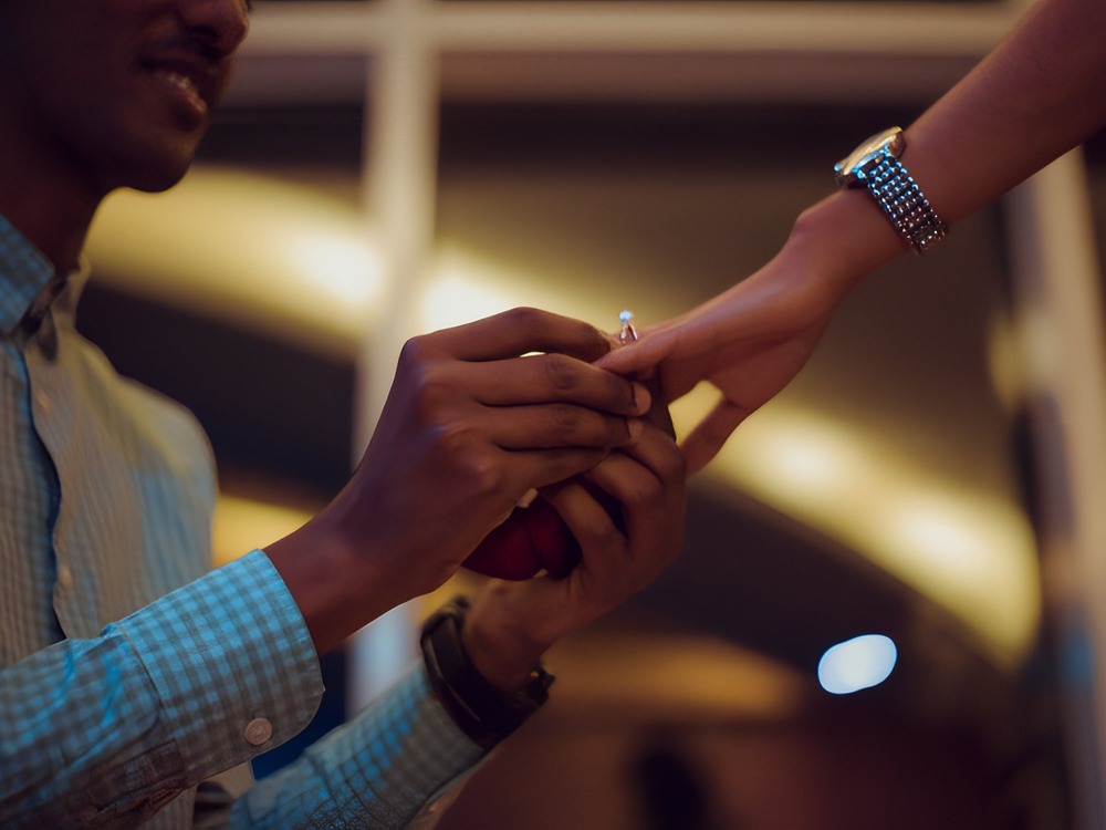 A romantic wedding proposal idea: in the soft, dim lighting of your dream destination wedding location, gently slip the ring onto their finger for a truly unforgettable moment.