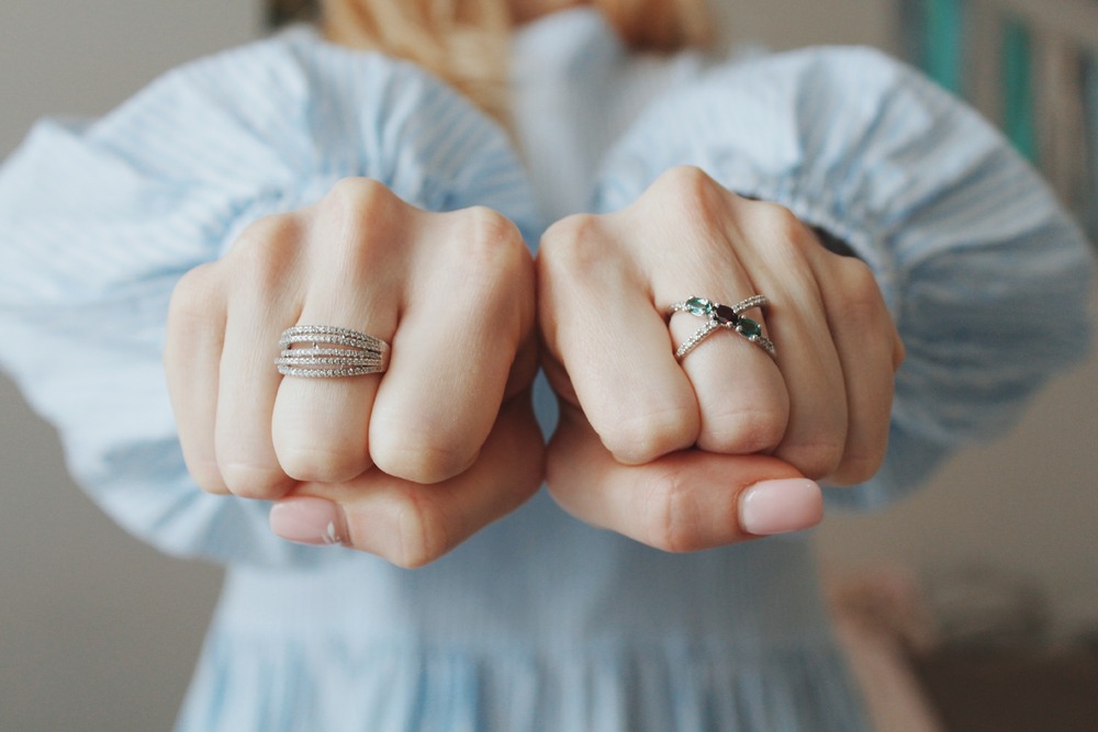 Two fists adorned with silver rings, including a stunning lab-grown diamond wedding ring on the middle finger, make a bold statement—perfect inspiration for your destination wedding.