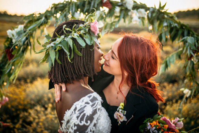 Two women kiss as newlyweds after their destination wedding