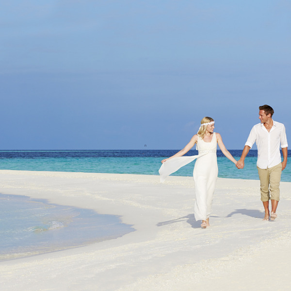 Couple holding hands and strolling on the beach after their Dominican Republic wedding packages under $5000 destination wedding