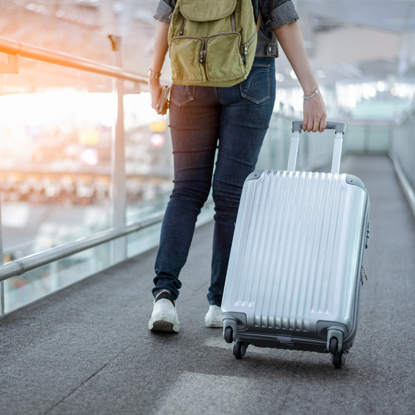 Woman carrying her luggage at an airport after a flight cancellation
