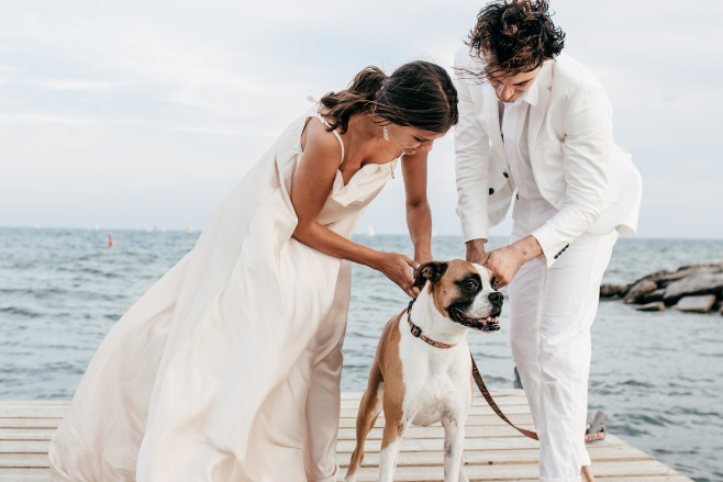 A couple with their dog in front of the ocean