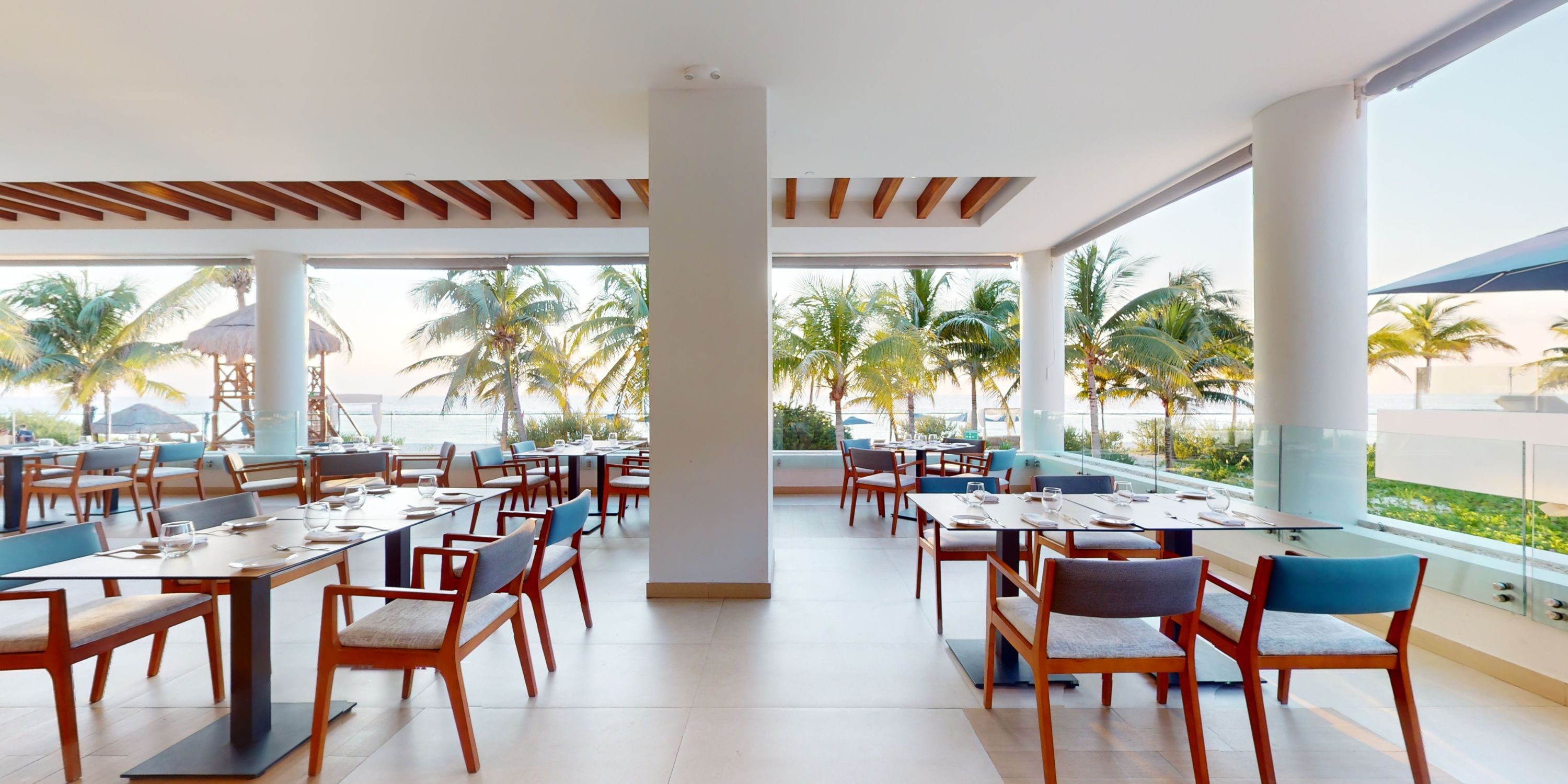 Elegant wedding dining setup at Royalton Splash Riviera Cancun, with set tables and palm tree views.