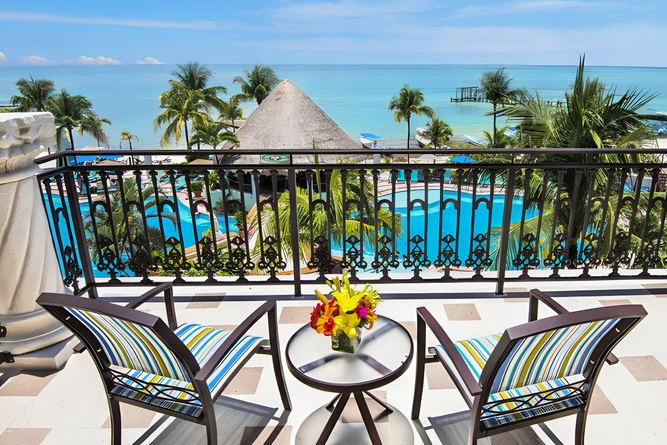 Lounge chairs on a balcony overlooking Wyndham Alltra Playa del Carmen