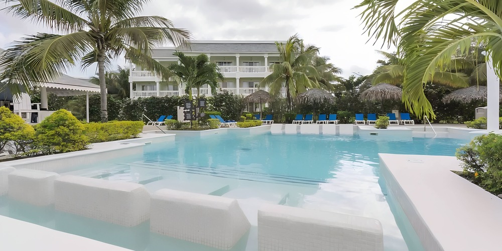 Outdoor pool lined with white lounge chairs, ideal for an intimate destination wedding of 20 guests.