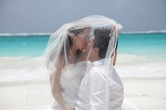 Couple kissing on the beach after their destination wedding