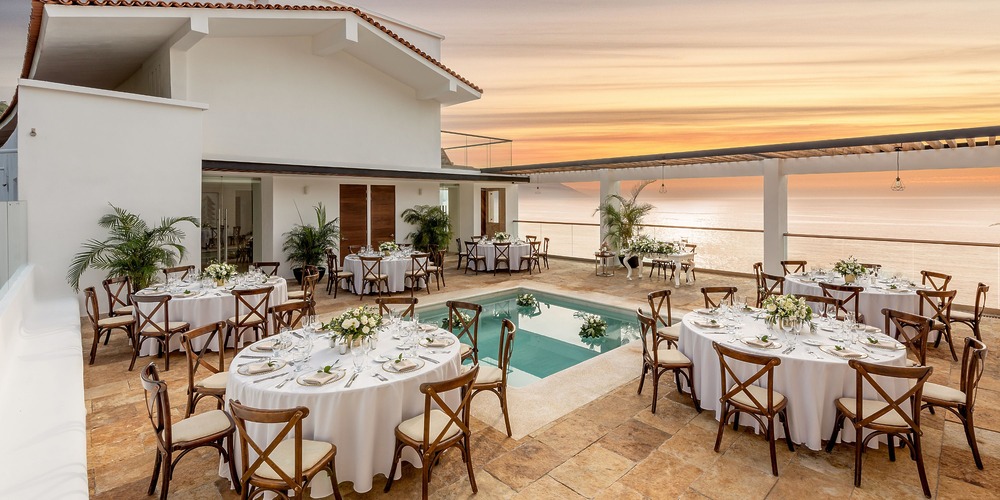 Enjoy al fresco dining on the outdoor terrace beside the pool at sunset—an idyllic setting for a romantic destination wedding in Mexico.