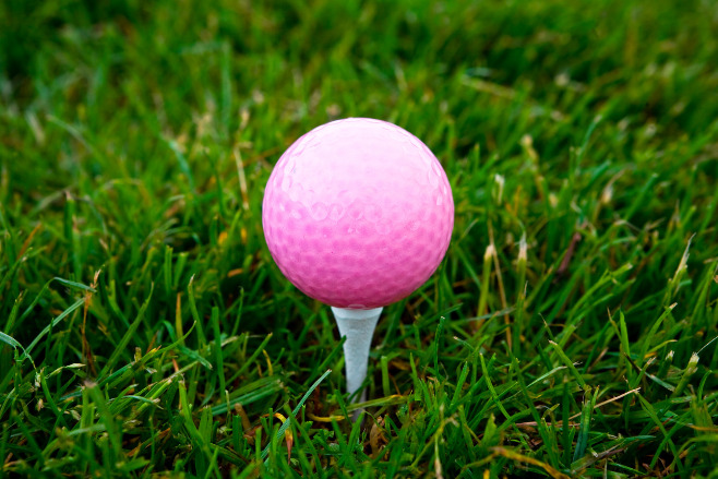 A pink golf ball on the grass