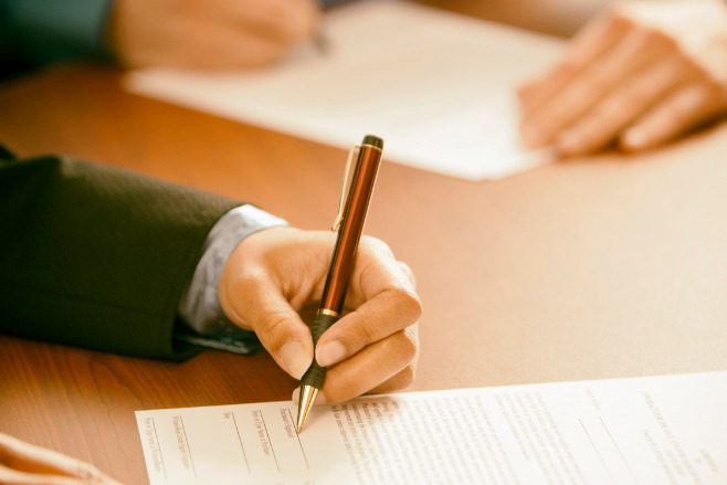 Someone signing the legal requirements of a Wedding in the Bahamas