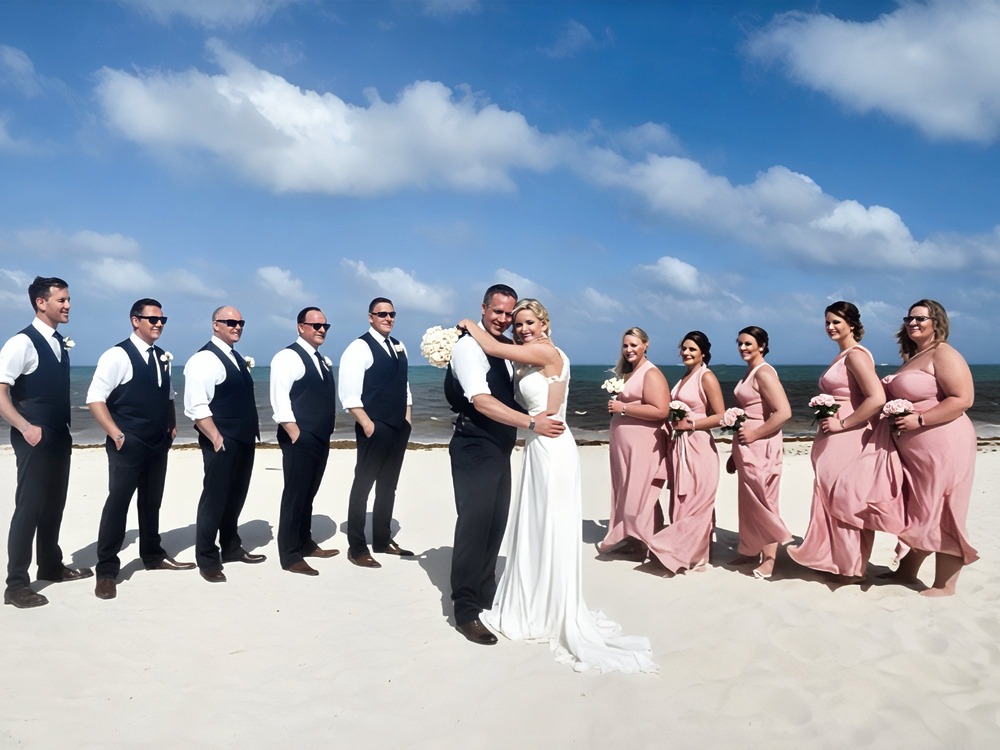 The bride and groom embrace on the beach, imagining what a destination wedding might cost.