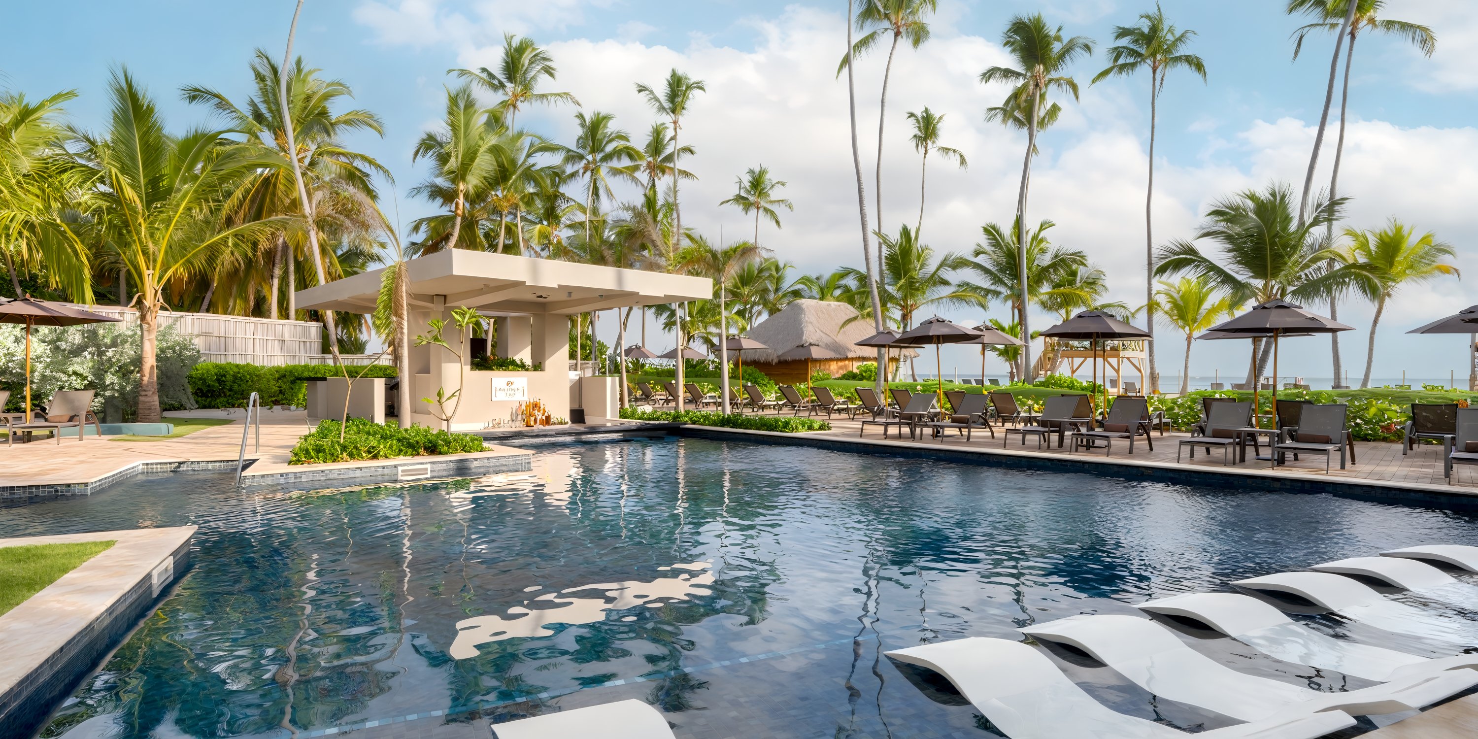 Dreams Flora: Outdoor pool with loungers, poolside bar, and palm trees—perfect destination wedding spot.