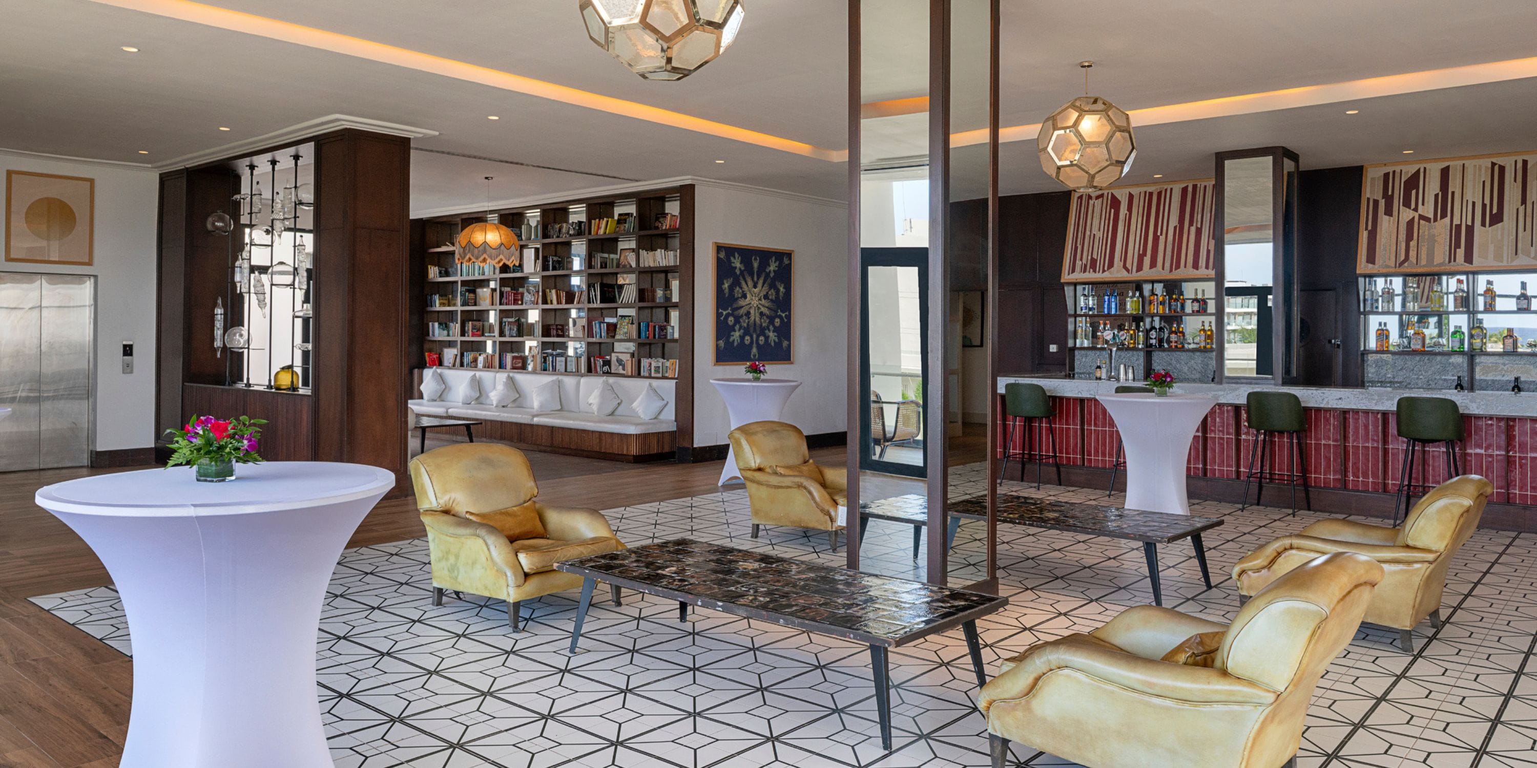 Ocean Coral Spring lounge, ideal for a destination wedding, with armchairs, bar, and bookshelf.