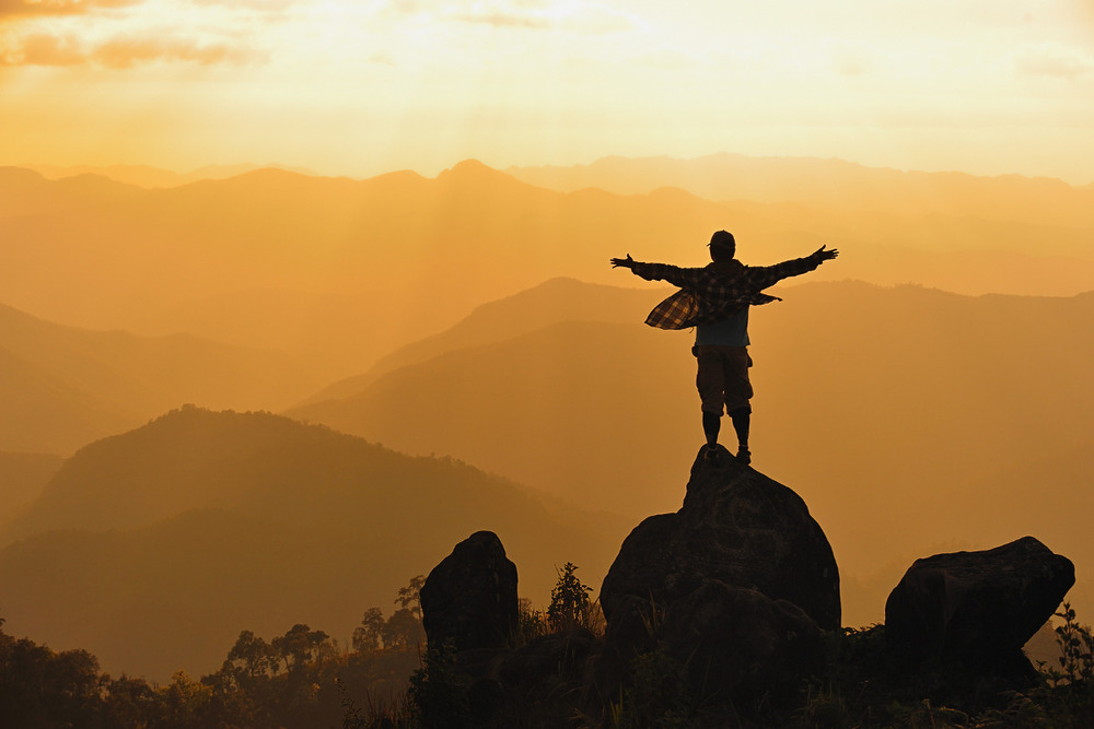 Man standing on mountain as the sun falls